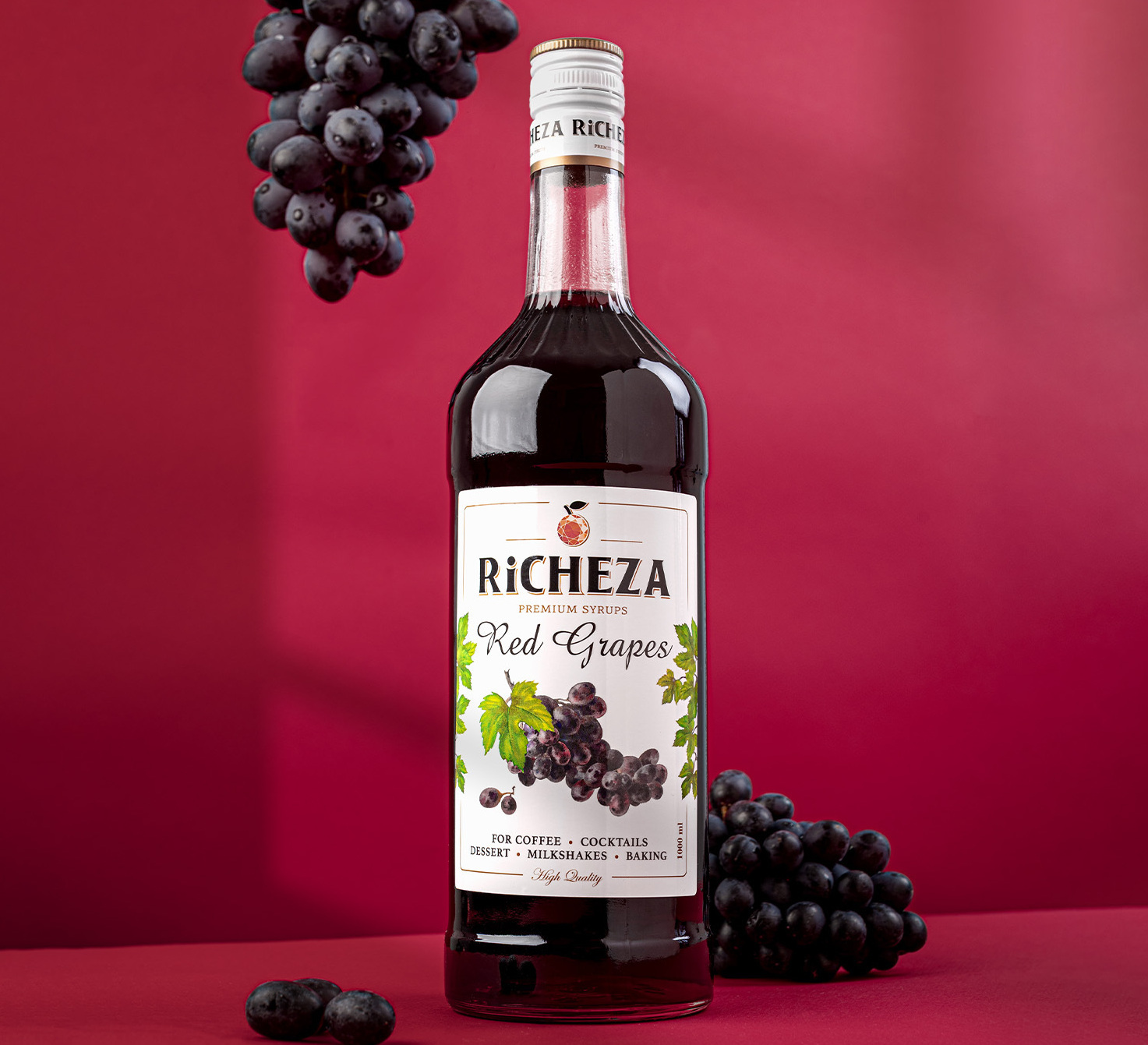 Стильная съемка виноградного сиропа на красном фоне